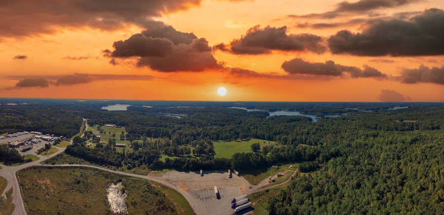 a stunning aerial panoramic shot of the blue waters of Lake Hartwell surrounded by vast miles of lush green trees and grass with powerful clouds at sunset in Fair Play South Carolina USA