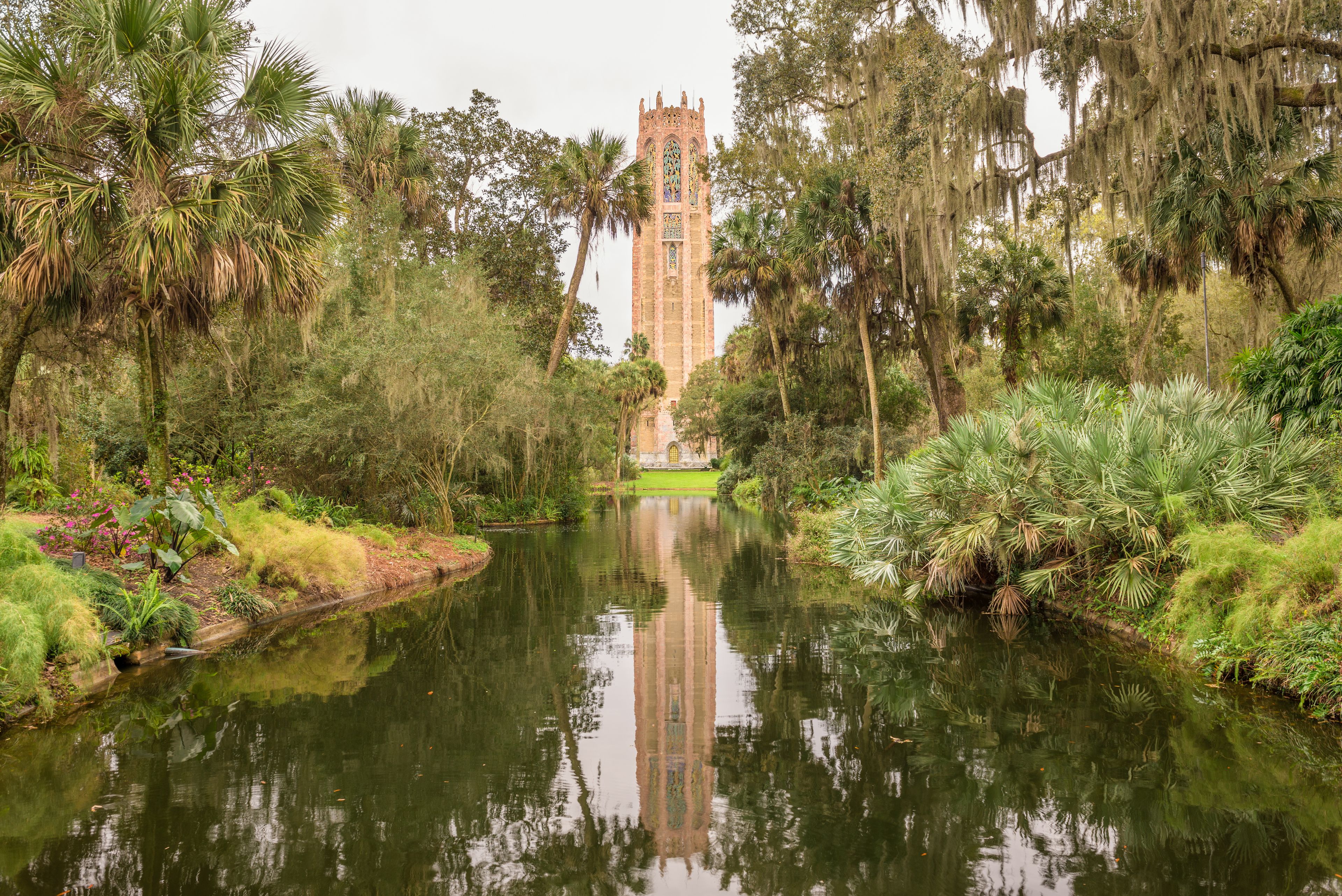 Ein ruhiger Fluss mit einem hohen Turm im Hintergrund.