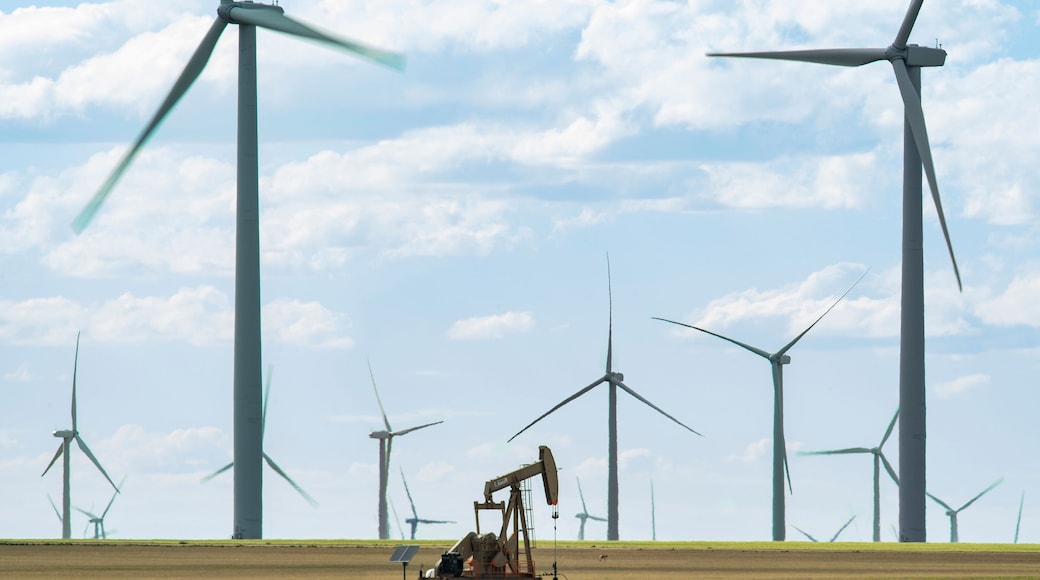 Solo Oil Derrick Stands Among Modern Windmills
