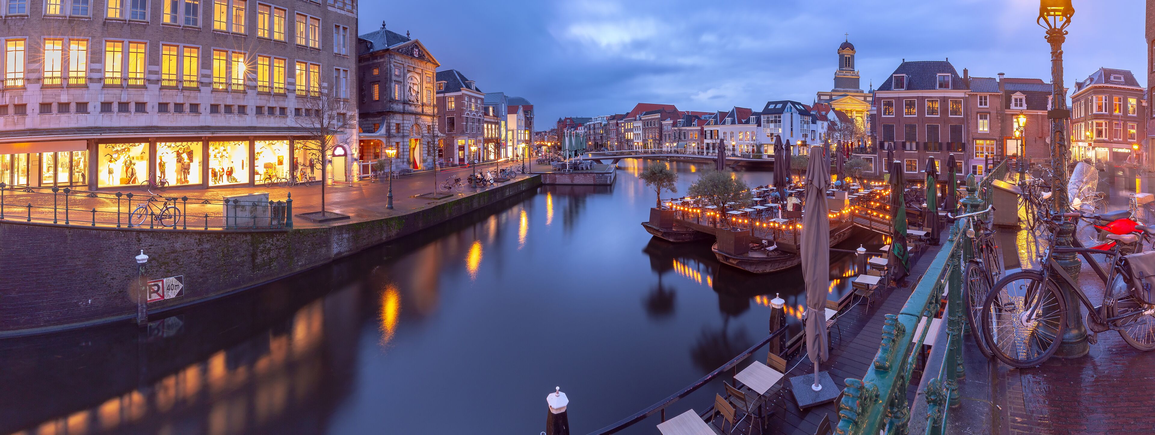 A canal with boats, a bridge, and historic buildings along the water.