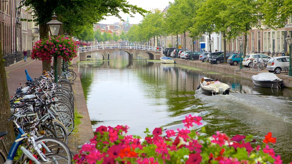 A canal with boats, bicycles, and a bridge.