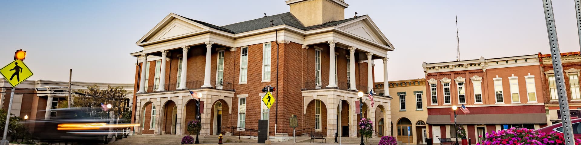 Morning traffic headlights illuminate the downtown square in Lancaster, Kentucky, with the historic courthouse as a backdrop in this small American town.