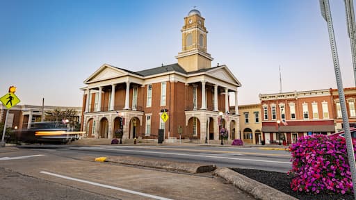 Morning traffic headlights illuminate the downtown square in Lancaster, Kentucky, with the historic courthouse as a backdrop in this small American town.