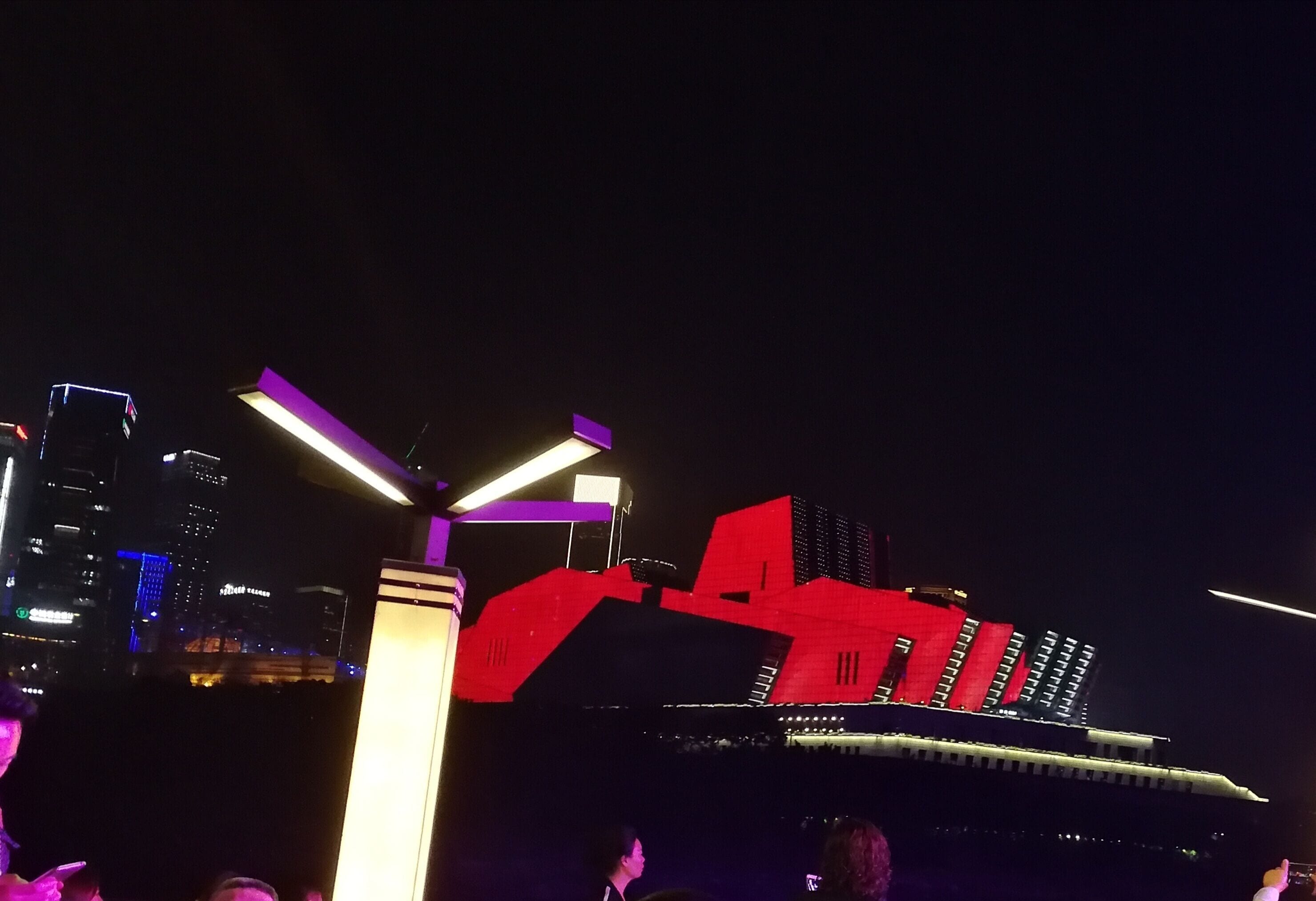 Chongqing Grand Theatre is grey by day. At night, when the city lights up, the theatre is transformed into a rainbow of colours which emphasise its striking architecture. 