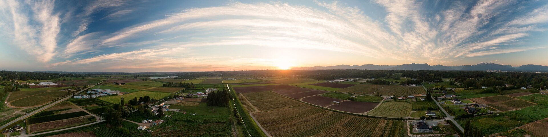 Aerial Panoramic View of Farm Fields in Fraser Valley during colorful Sunset. Taken in Langley, Greater Vancouver, British Columbia, Canada.