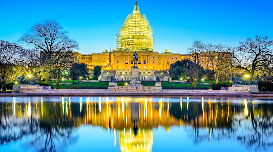 The United States Capitol building with its reflection in a body of water.