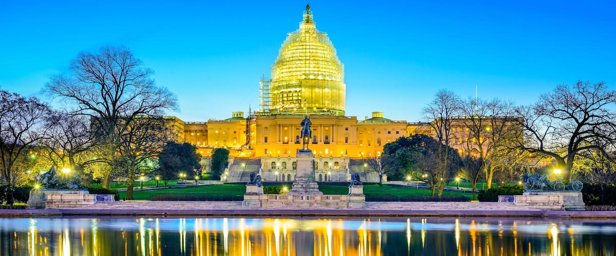 The United States Capitol building with its reflection in a body of water.