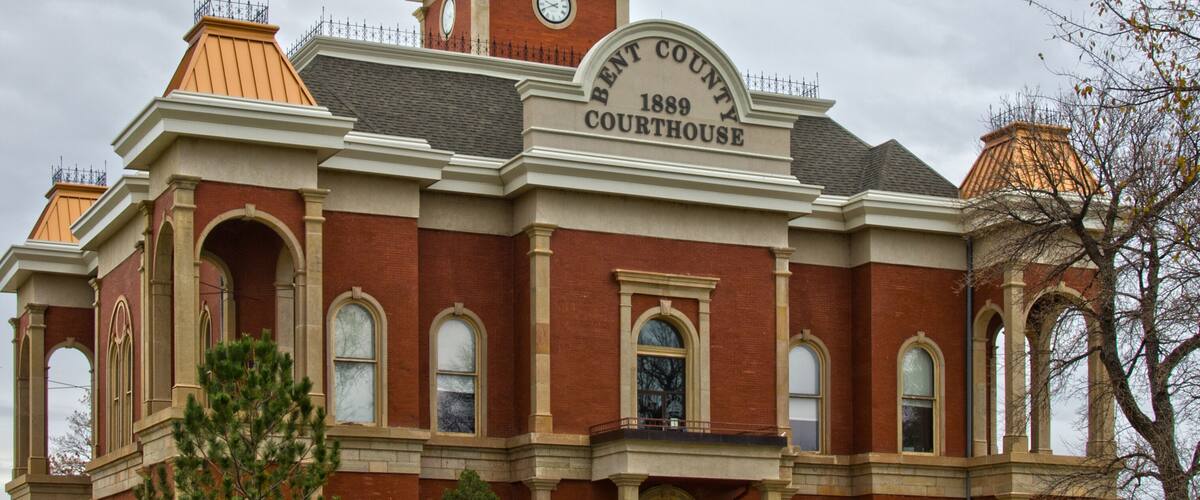 Een groot bakstenen gerechtsgebouw met een klokkentoren en een bord waarop staat: "Benton County Courthouse 1889".