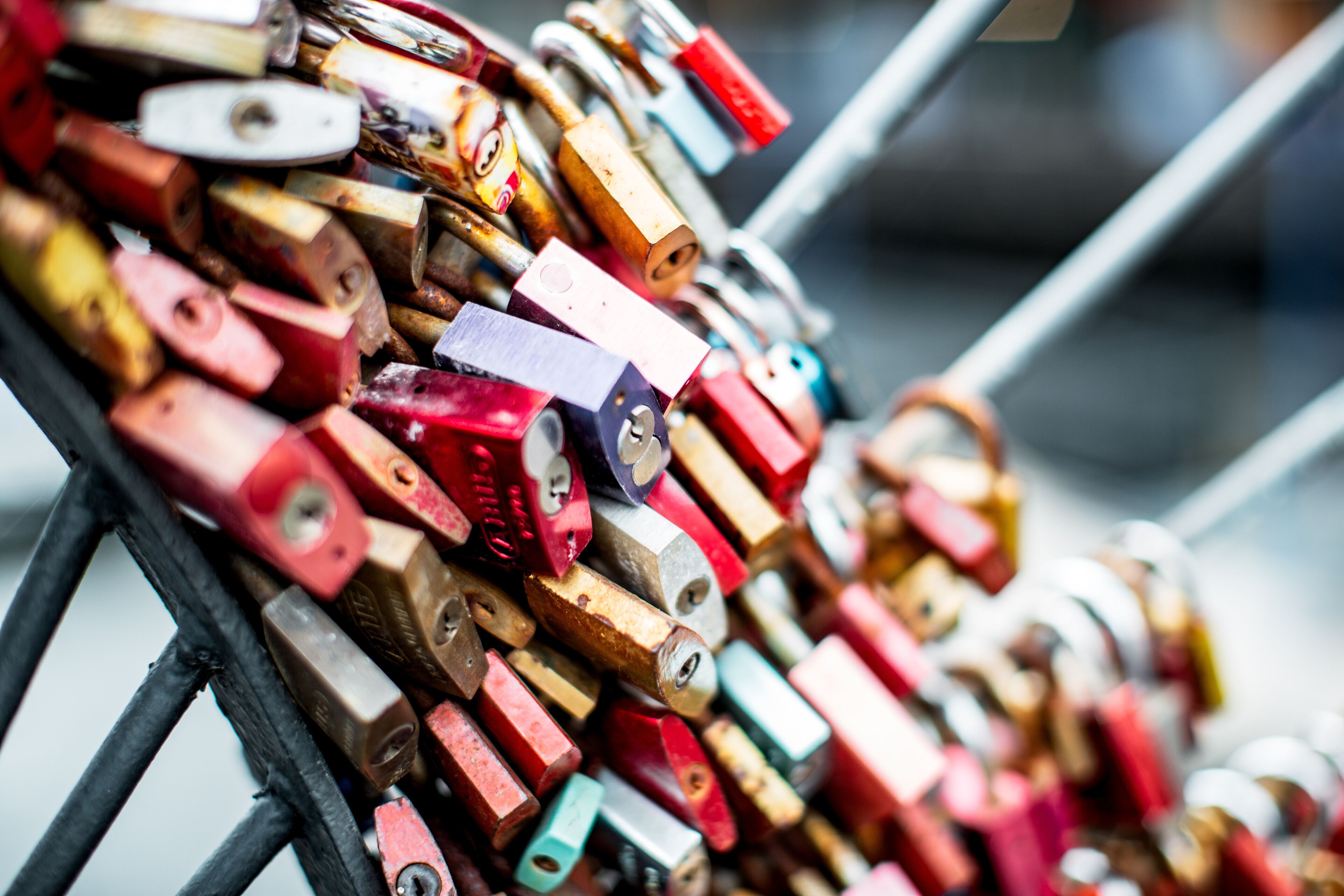 A collection of colorful padlocks stacked on a metal rack.