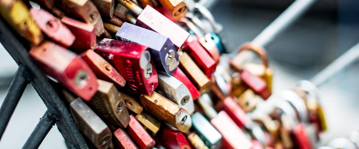 A collection of colorful padlocks stacked on a metal rack.