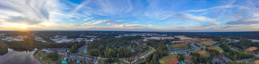 Vista panorâmica de uma cidade, com rio, áreas verdes e uma extensa zona industrial.