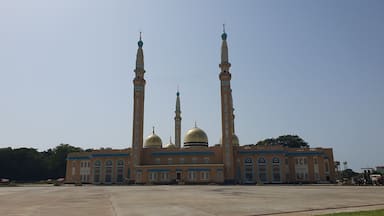 Une grande mosquée dotée de trois hauts minarets et de coupoles dorées.