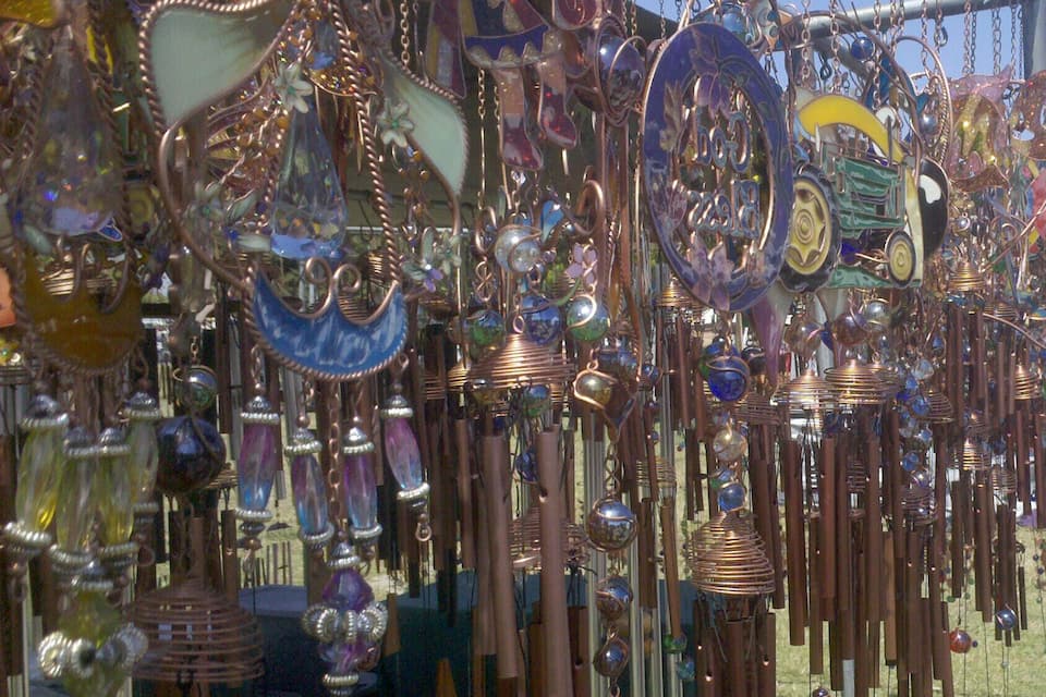 A variety of hanging decorative items, including glass orbs, metal sculptures, and possibly wind chimes.