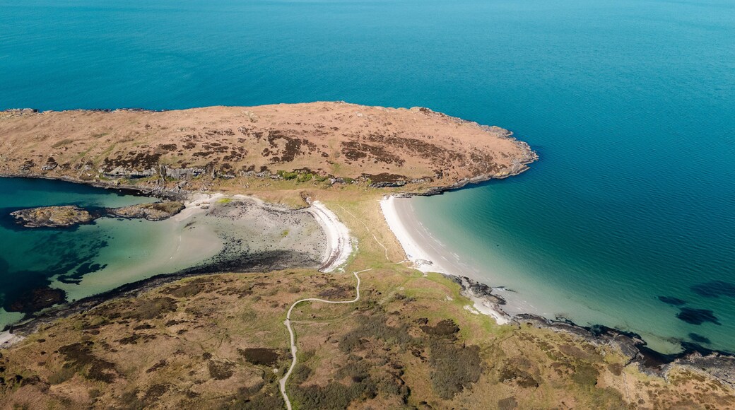 Aerial view of the Twin Beach with turquoise waters meeting the rugged shores, Isle of Gigha, Argyll and Bute, Scotland.
