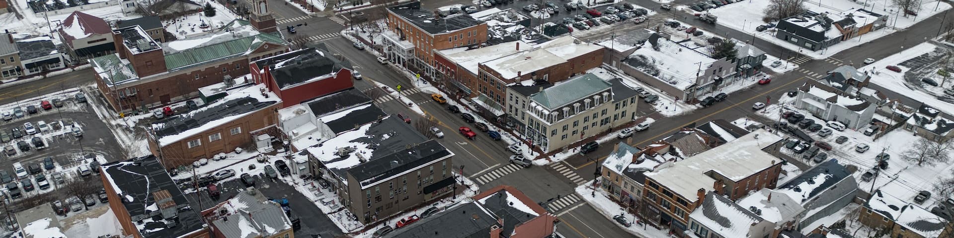 An aerial view of historic downtown Lebanon, Ohio, with Broadway Street visible in the center, is shown in an aerial view during a snowy winter day.