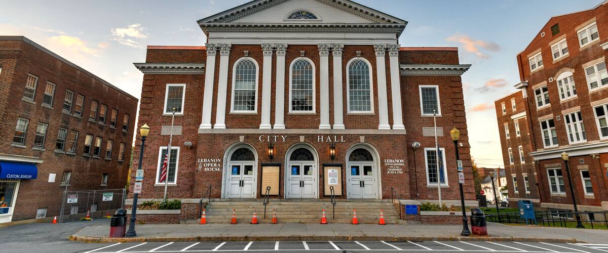 A historic building with a clock tower, named "City Hall," featuring arched windows and a prominent entrance.