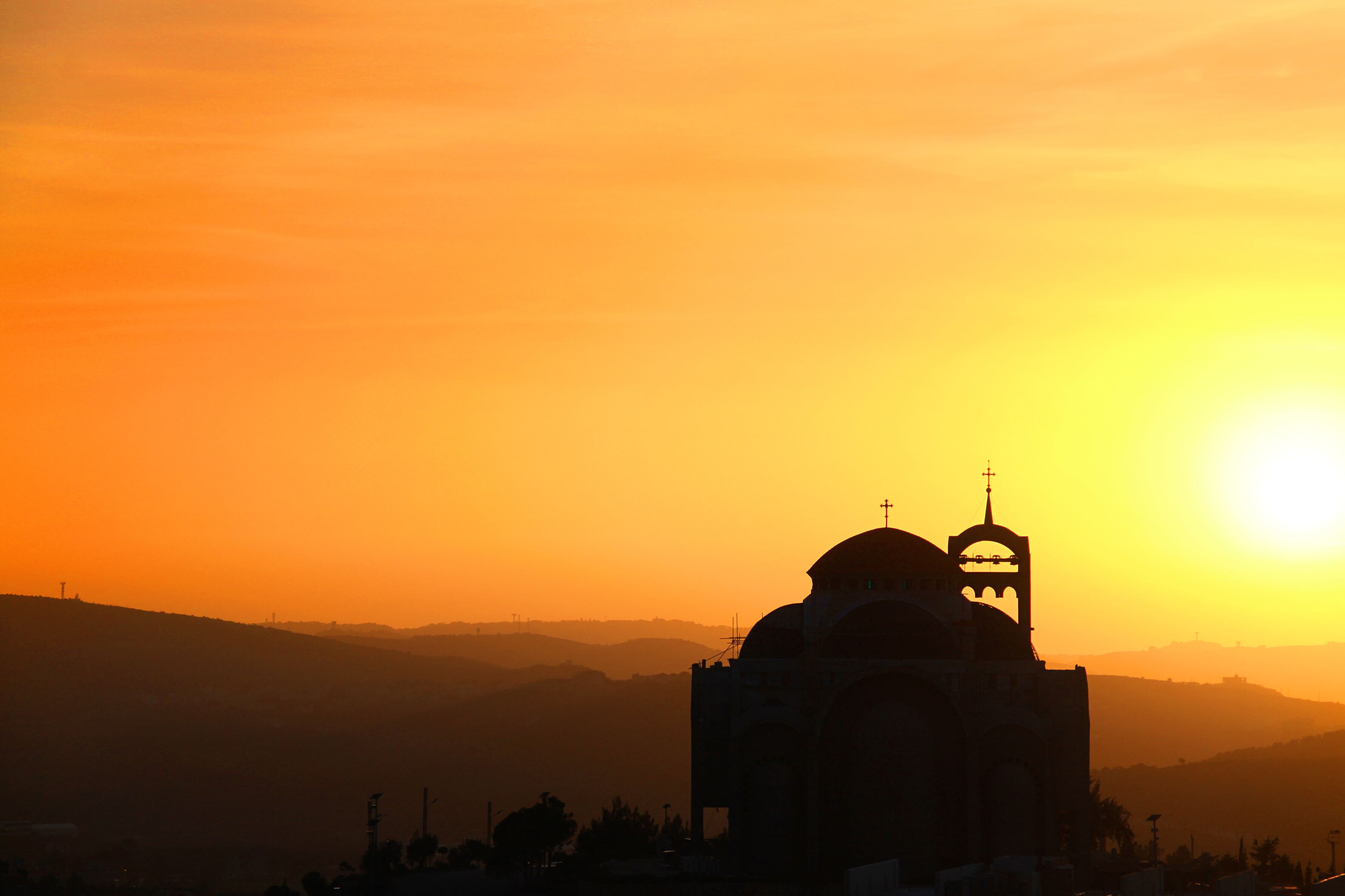 Silhueta de uma igreja contra um céu de pôr do sol.