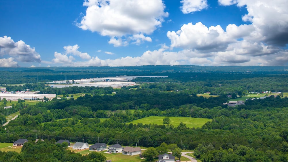 aerial shot of vast miles of lush green trees and the ALDI distribution center at the Nashville Superspeedway in Lebanon Tennessee USA