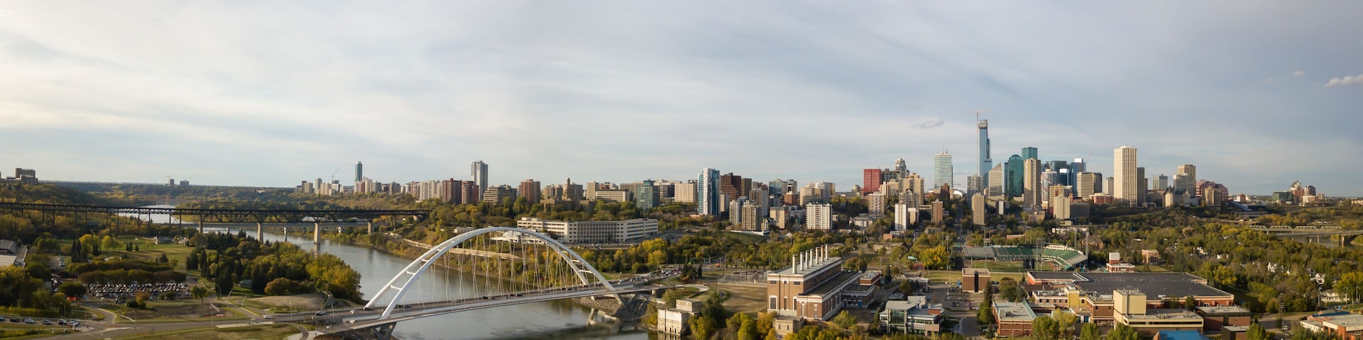 A river with a bridge, a city skyline, and a park.