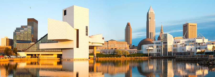 A city skyline with modern architecture, including a distinctive building with a curved facade and a tall skyscraper with a pointed top.