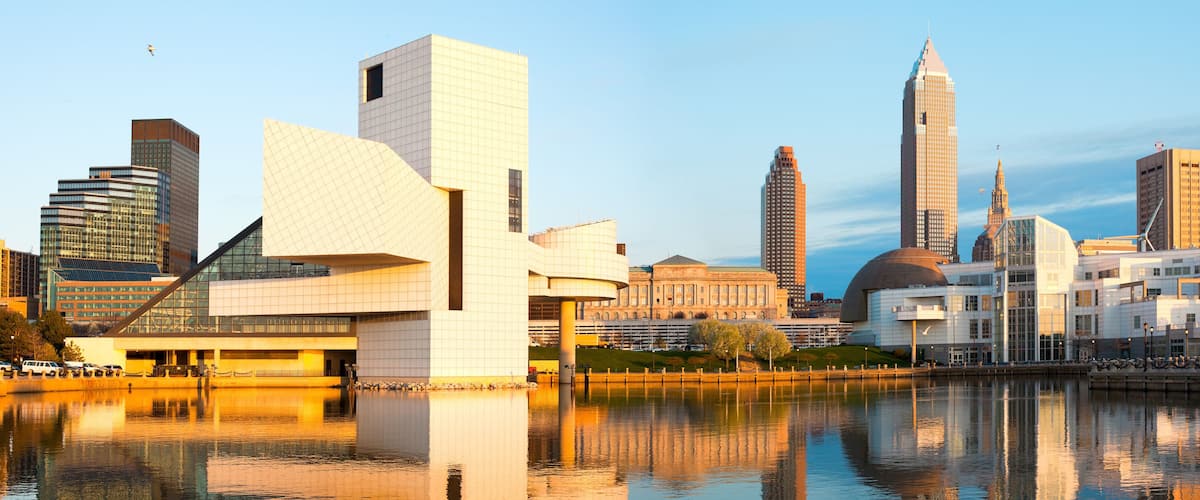 A city skyline with modern architecture, including a distinctive building with a curved facade and a tall skyscraper with a pointed top.