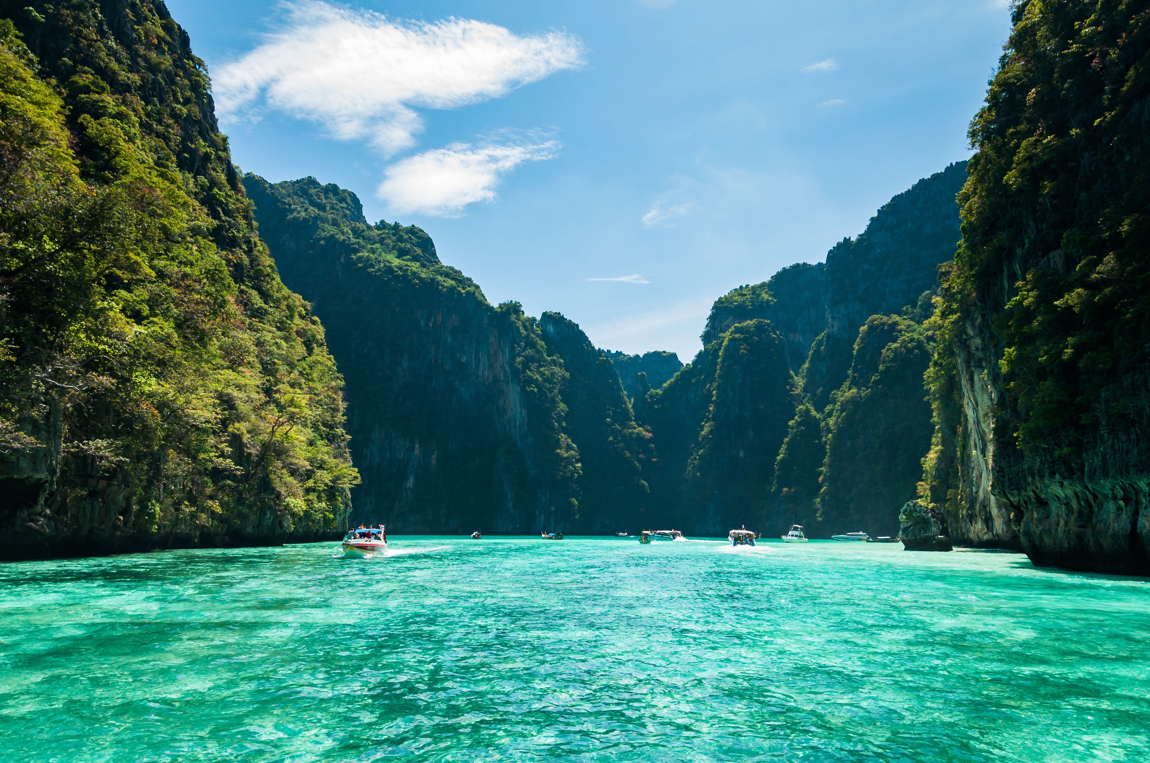 A turquoise sea surrounded by lush green cliffs.