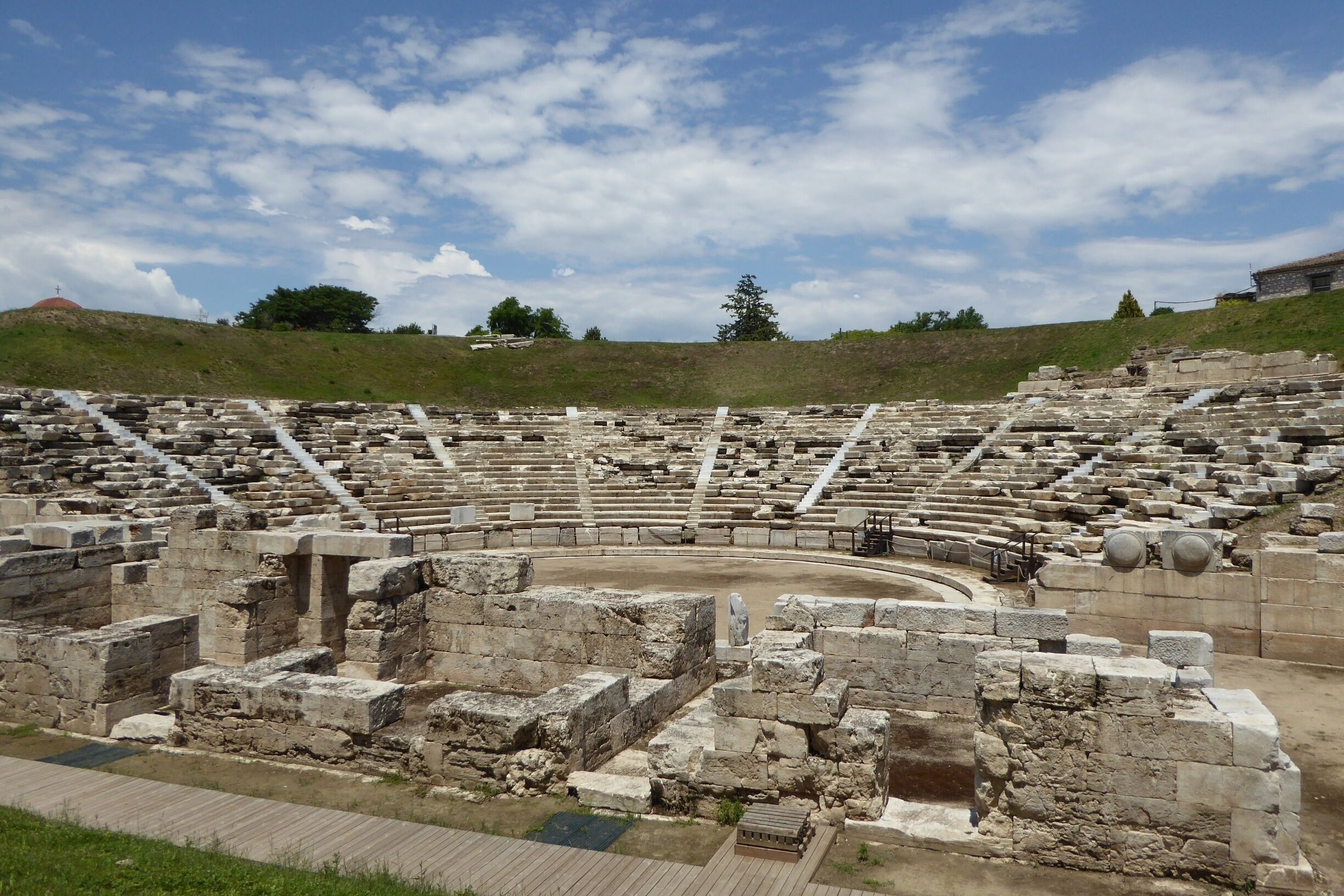 The Ancient Theatre of Larissa, Greece is modest by the scale of many Greek ruins. But it lies in the heart of the city just beside the street, it is easily viewed and really attractive.