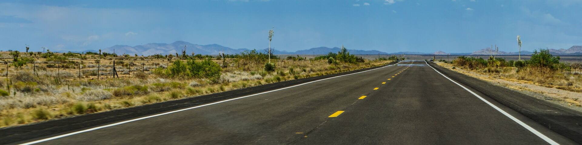 New Mexico highway state route 90, northbound from Lordsburg to Silver City, Gila Mountains in the distance above heat waves on the pavement