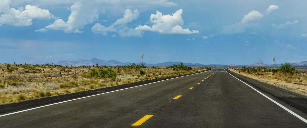 New Mexico highway state route 90, northbound from Lordsburg to Silver City, Gila Mountains in the distance above heat waves on the pavement