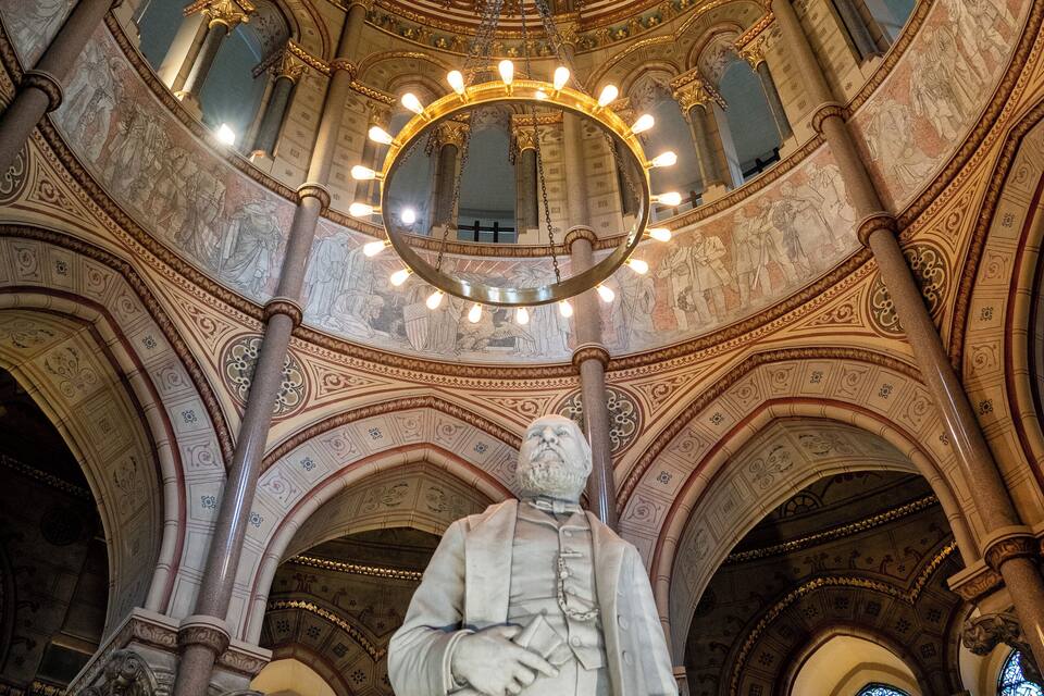 En imponerende indretning med et stort kuppelhvælv, detaljerede freskomalerier og en markant statue.