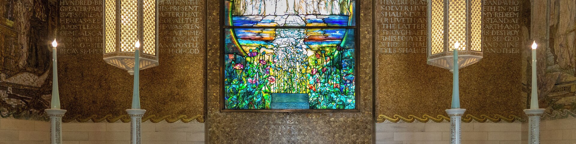 The Neo-Classical Wade Memorial Chapel is a beautiful little building set alongside an ornamental lake in Lake View Cemetery in Cleveland. The chapel was built in 1901 in honor of Jeptha Wade, a Cleveland industrialist who founded Western Union Telegraph.
And while the outside of Wade Chapel is pretty, it’s really the inside that’s the star. The interior of Wade Memorial Chapel was completely designed by Louis Comfort Tiffany – in fact, it’s one of the only remaining Tiffany-designed interiors that still exists.
The interior of Wade Chapel is themed around “The Voyage of Life.” The walls are covered in large glass mosaics, with one wall depicting “The River of Life” and another “The River of Death.” The central piece of the chapel is a large stained glass window titled “The Flight of Souls.”