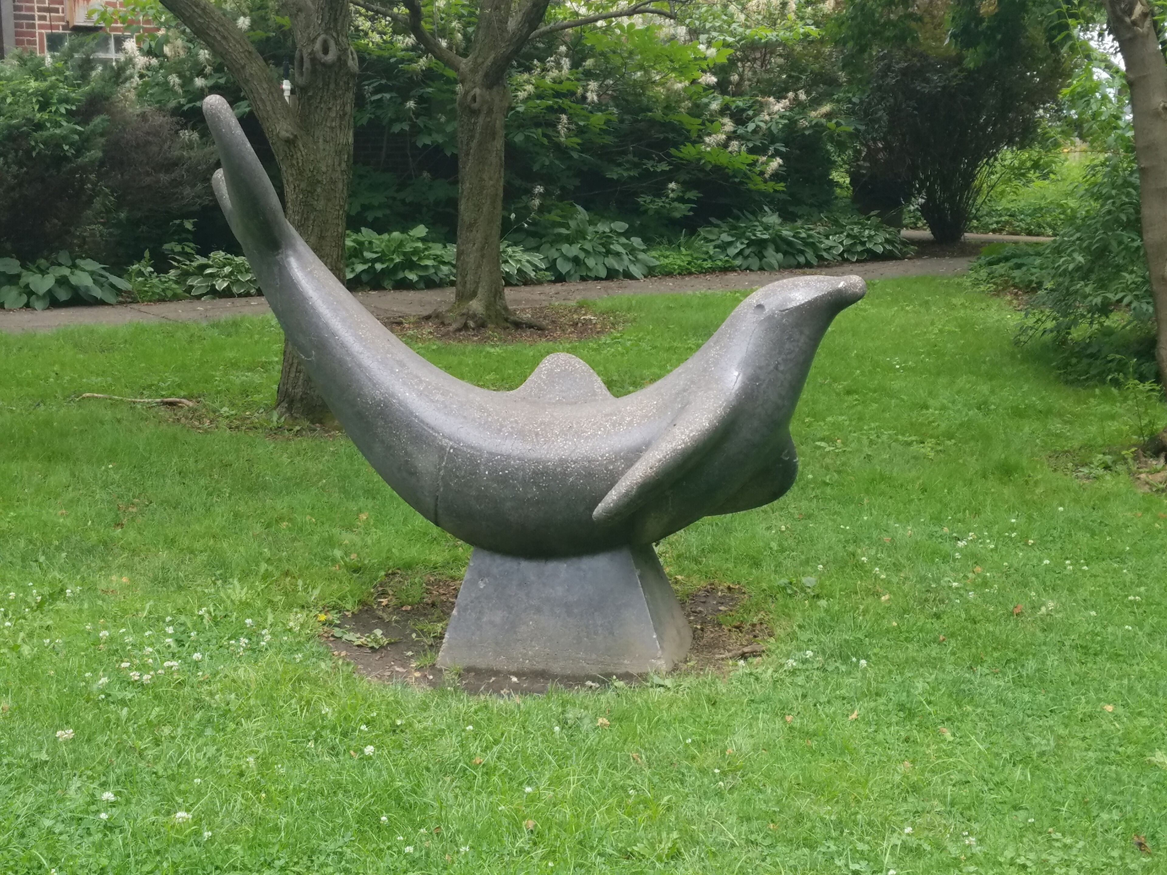 A statue of a playful Porpoise on the grounds of the park.