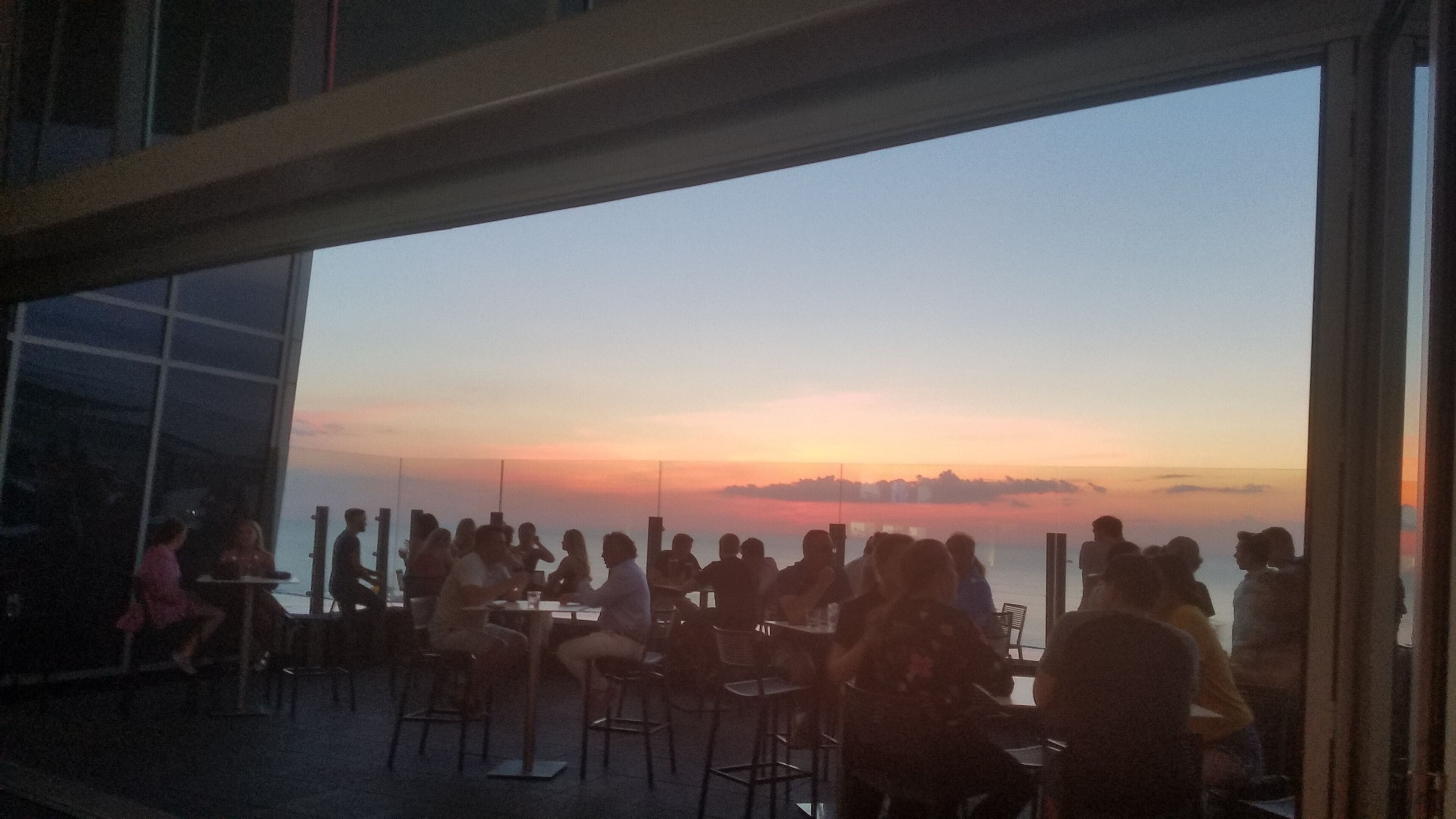 View of the July sunset over Lake Erie from inside the 32nd floor rooftop bar. This is atop the Downtown Hilton.