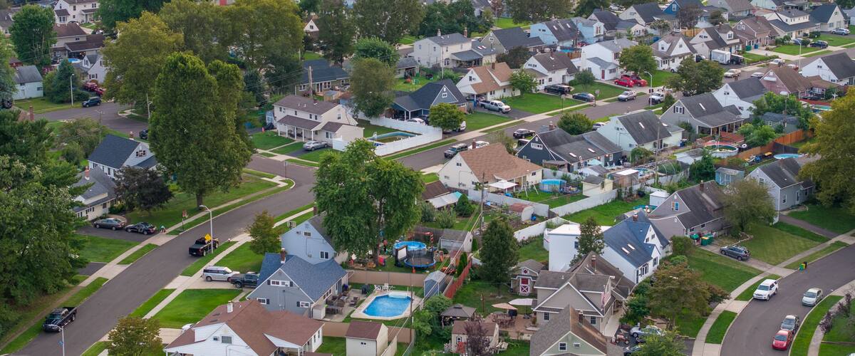 A suburban neighborhood with houses, streets, and a swimming pool.