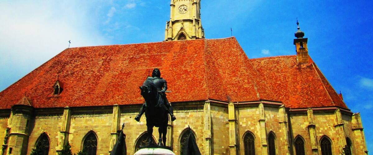 The Church of Saint Michael is a Gothic-style Roman Catholic church in Cluj-Napoca. It is the second largest church (after the Black Church of Brașov) in the geographical region of Transylvania, Romania. The nave is 50 meters long and 24 meters wide, the apse is 20×10 m. The tower with its height of 76 meter (80 meter including the cross) is the highest one in Transylvania. The western portal is decorated with the three coats of arms of Sigismund as King of Hungary, as King of Bohemia and as Holy Roman Emperor.
Source:Wikipedia