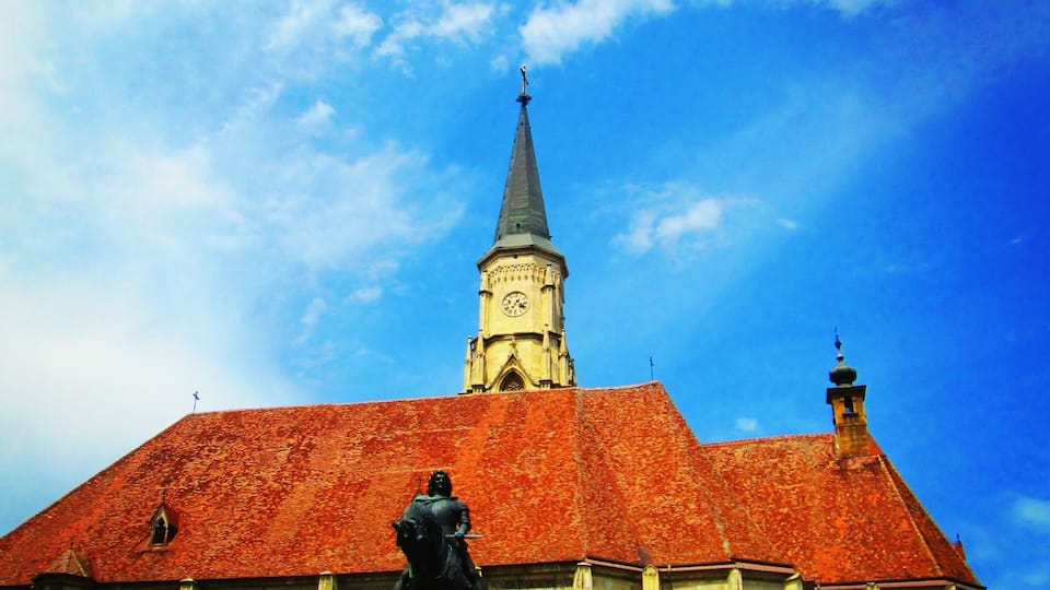 The Church of Saint Michael is a Gothic-style Roman Catholic church in Cluj-Napoca. It is the second largest church (after the Black Church of Brașov) in the geographical region of Transylvania, Romania. The nave is 50 meters long and 24 meters wide, the apse is 20×10 m. The tower with its height of 76 meter (80 meter including the cross) is the highest one in Transylvania. The western portal is decorated with the three coats of arms of Sigismund as King of Hungary, as King of Bohemia and as Holy Roman Emperor.
Source:Wikipedia
