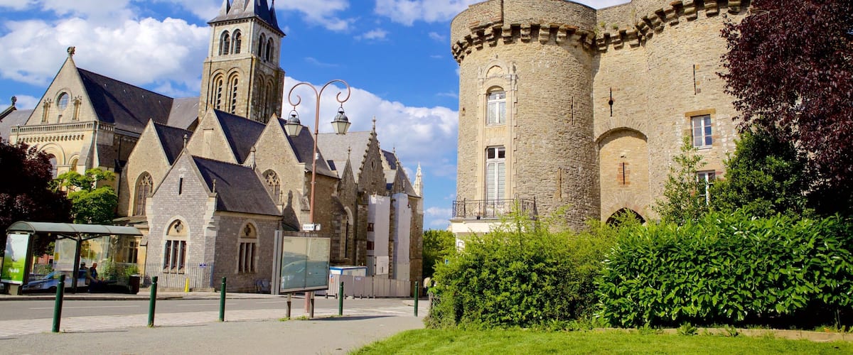 A historic church with a tall bell tower and a large stone building with a round tower.