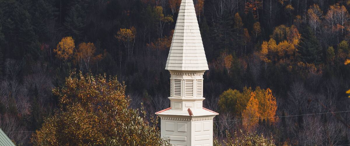 View of the white chapel, steeple in Dog Mountain, St. Johnsbury, VT, foliage, during autumn