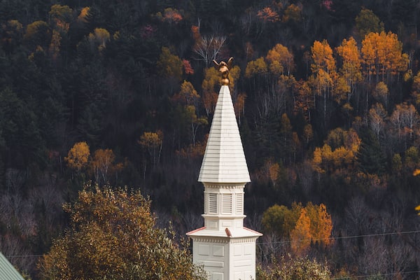 View of the white chapel, steeple in Dog Mountain, St. Johnsbury, VT, foliage, during autumn
