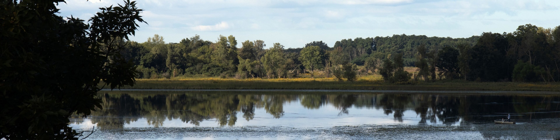 Ultra-wide panorama of Turner Lake and native prairie grasses and trees in autumn at Moraine Hills State Park in McHenry County, Illinois