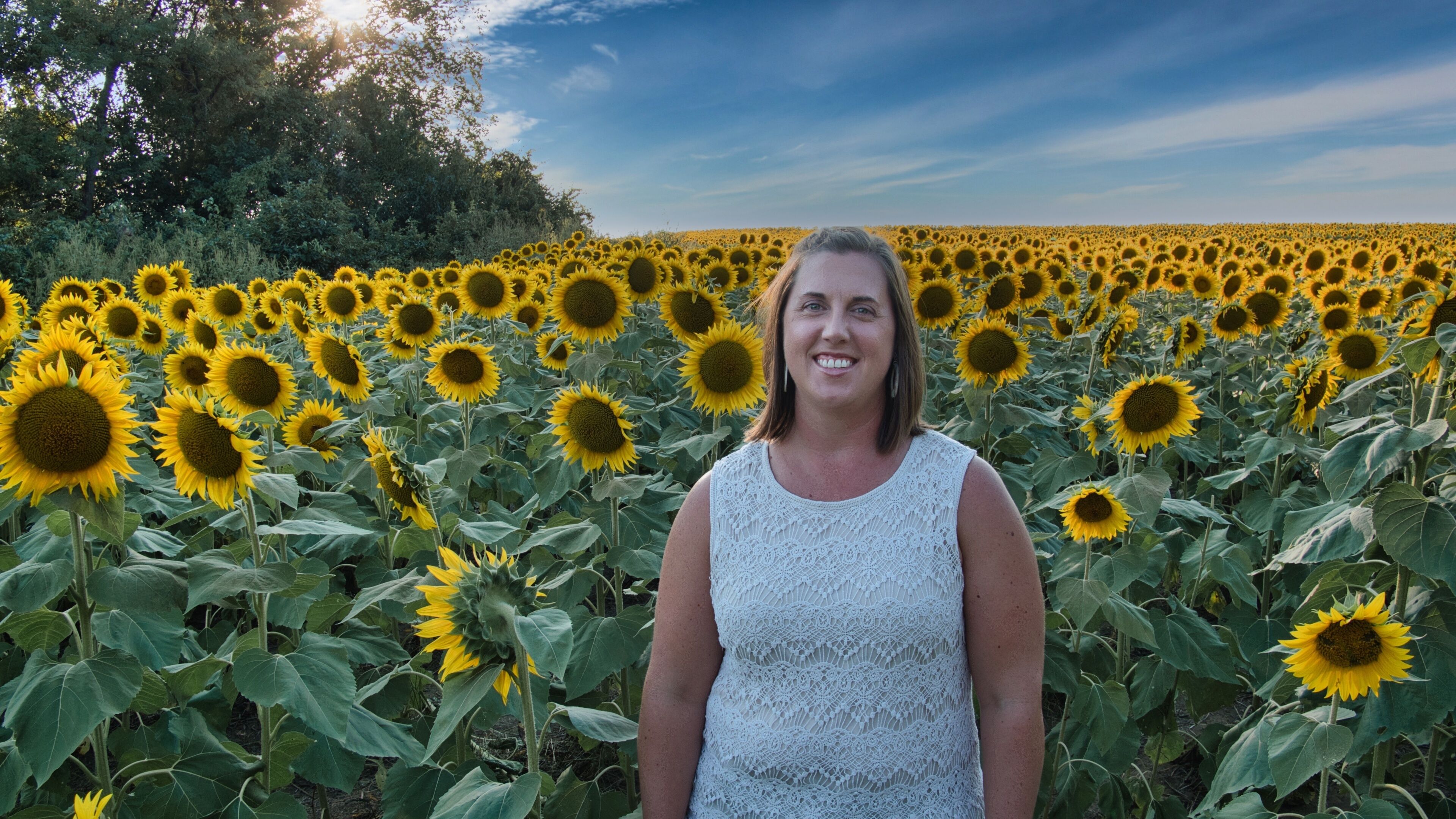 Woman Standing in Large Sunflower Field in Kansas