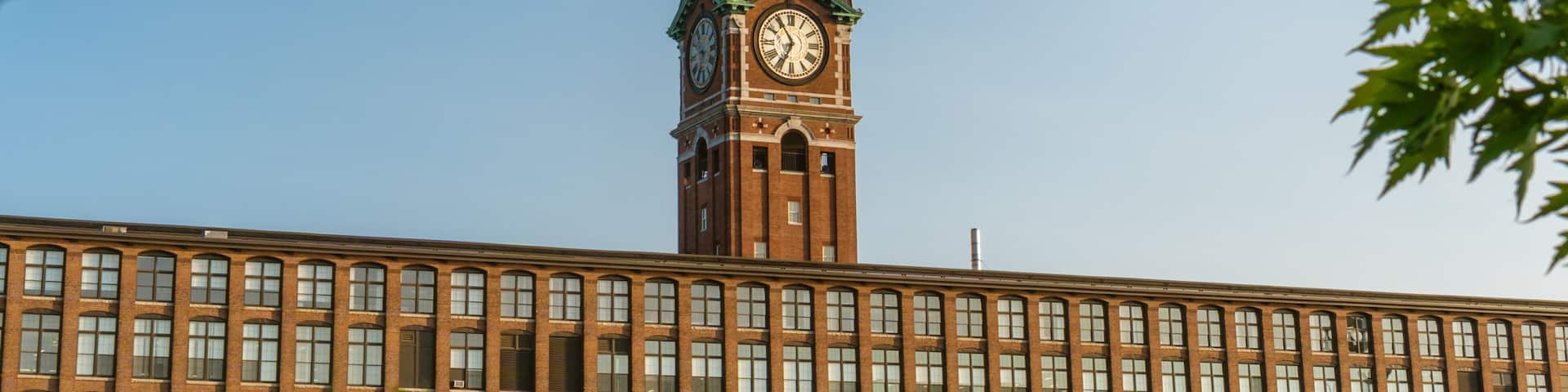 Iconic clock tower and nineteenth century brick mill building in the historic immigrant city of Lawrence Massachusetts.