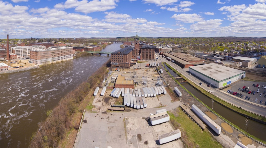 A river with industrial buildings and a bridge.