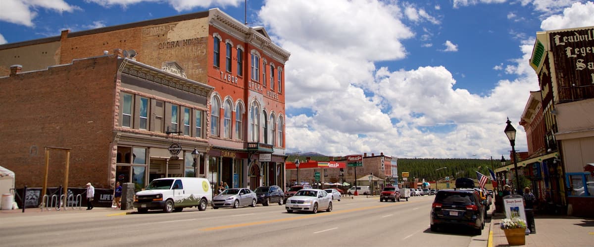 A street with historic buildings, including an opera house, and a clear blue sky with clouds.