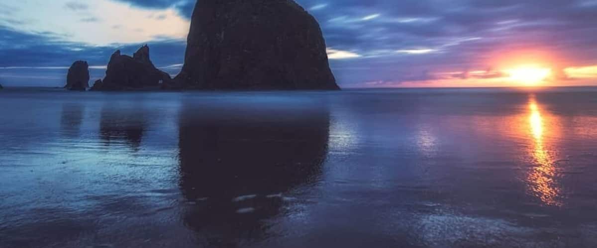 Haystack Rock on Cannon Beach is one of Oregon’s most recognisable landmarks. The views all the way down the Oregon Coast along Highway 101 are nothing short of spectacular and Cannon Beach where our journey began did not disappoint, this place is beautiful.
We had some pretty thick cloud cover for sunset so I thought a long exposure would work great to capture their movement. I didn’t get the colour I was hoping for, however as the sun dipped over the horizon it left a beautiful glow and reflection on the water 😍