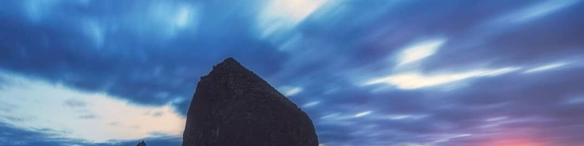 Haystack Rock on Cannon Beach is one of Oregon’s most recognisable landmarks. The views all the way down the Oregon Coast along Highway 101 are nothing short of spectacular and Cannon Beach where our journey began did not disappoint, this place is beautiful.
We had some pretty thick cloud cover for sunset so I thought a long exposure would work great to capture their movement. I didn’t get the colour I was hoping for, however as the sun dipped over the horizon it left a beautiful glow and reflection on the water 😍