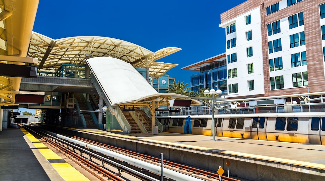 View of the platforms and modern architectural design of the Millbrae Transit Station with a bart train and urban housing near San Francisco in California, United States