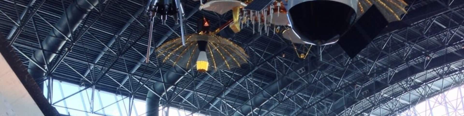 A space shuttle with NASA and United States logos, inside a large hangar.