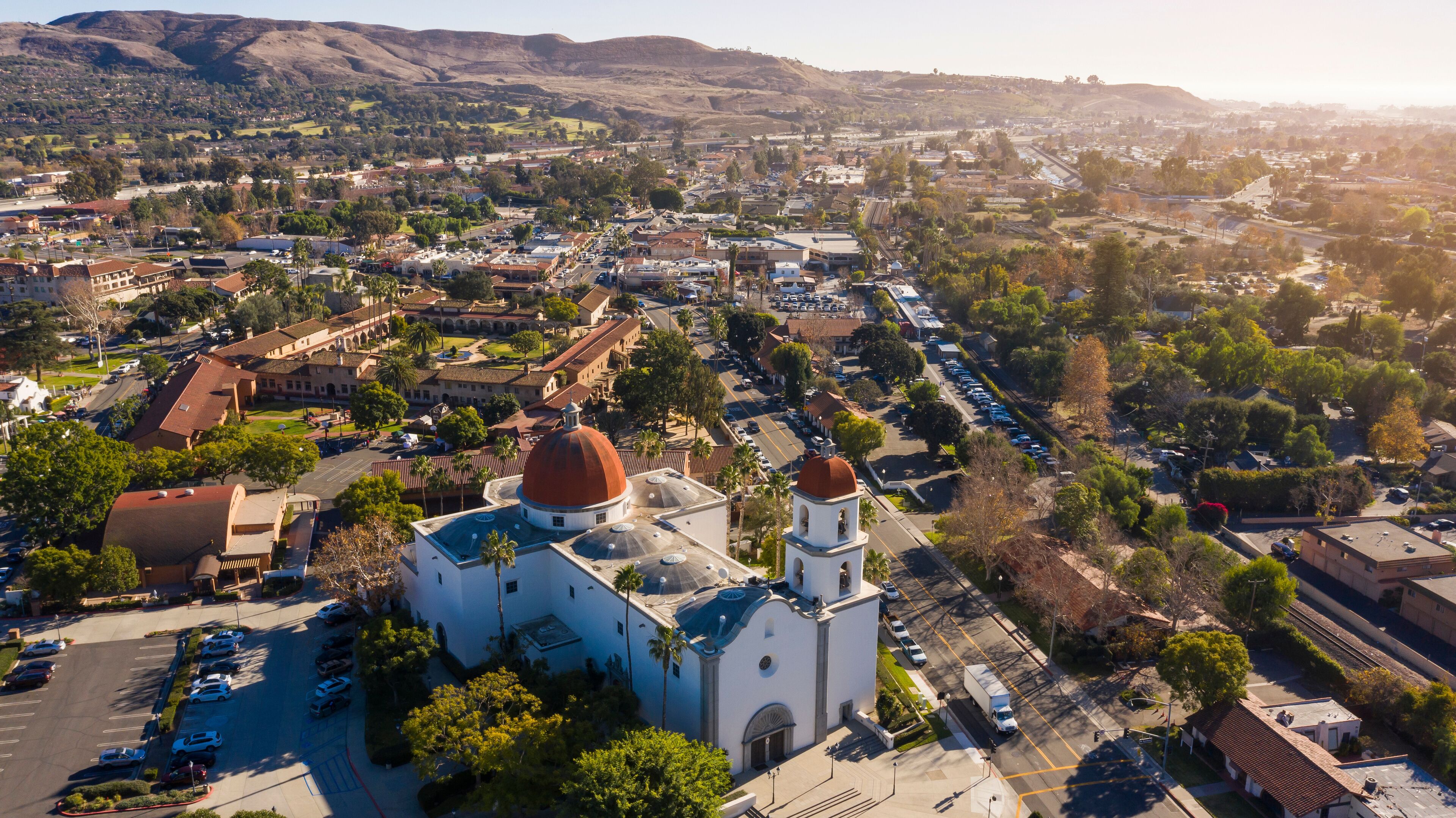 Daytime aerial view of the Spanish Colonial era mission and surrounding city of downtown San Juan Capistrano, California, USA. 