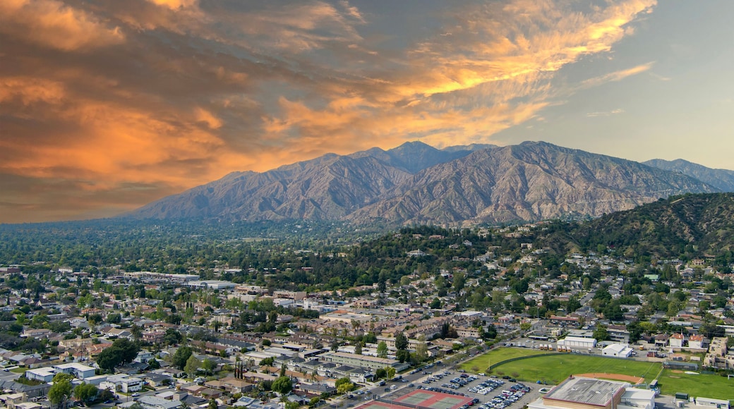 aerial shot of majestic mountain ranges with homes, lush green trees and cars on the street in Monrovia California USA